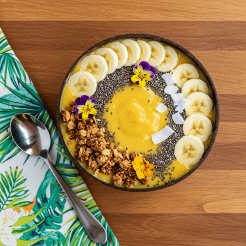 A smoothie bowl topped with granola, coconut, and banana slices