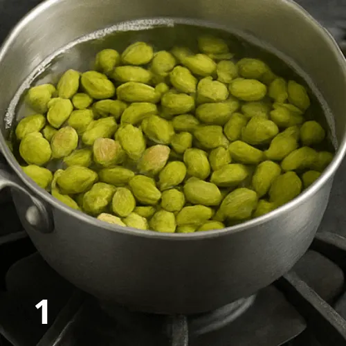 Boiling pistachios in a pot, then chilling them in ice water and peeling off the skins on a towel.