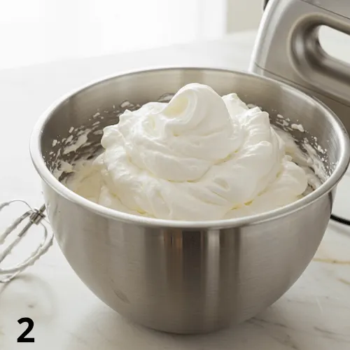 Heavy whipping cream being beaten to soft peaks with a mixer for ice cream.
