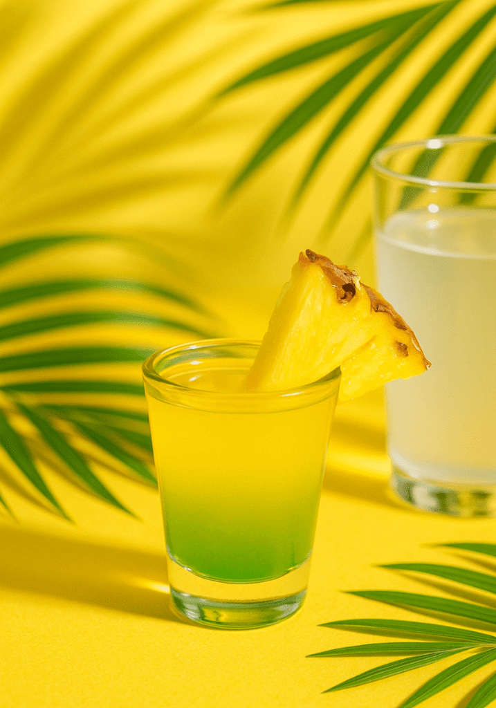 Alcohol-free tropical green tea shot with pineapple, lime, and coconut water for a vacation vibe