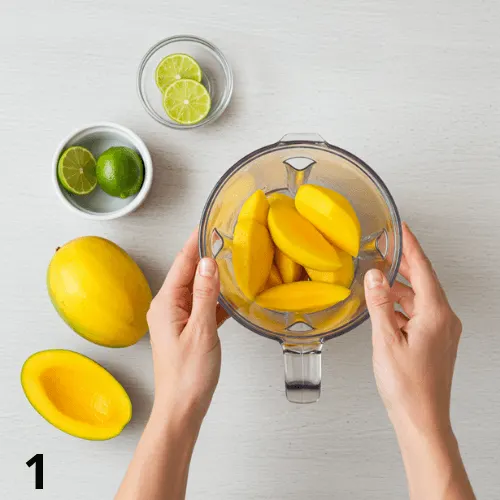 Peeled and chopped mangoes being blended with lime juice for smooth mango purée.