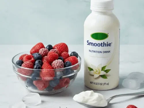 Ingredients for a fruit smoothie displaying a bottle of vanilla Boost drink, frozen berries, Greek yogurt, and chia seeds.
