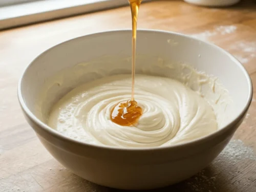 Honey being gently added to whipped eggs to give Castella cake its signature sweetness.