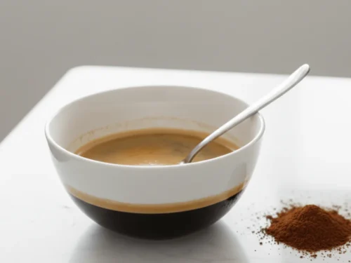 Freshly brewed espresso mixed with liqueur and espresso powder in a bowl.