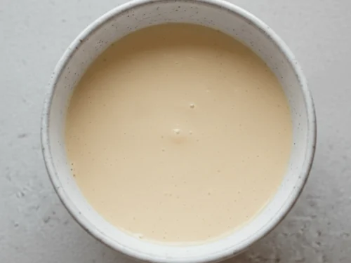 Uncooked protein mug cake batter ready to be microwaved in a single-serve mug.