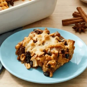 Traditional Mexican capirotada dessert baked with cheese, raisins, peanuts, and cinnamon syrup in a dish. A classic Easter recipe full of rich textures and flavors.