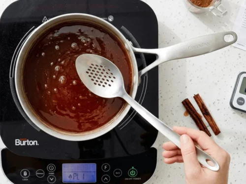 Cinnamon sticks simmering in sugar water to create syrup for capirotada. This mixture gives the dessert its signature flavor.